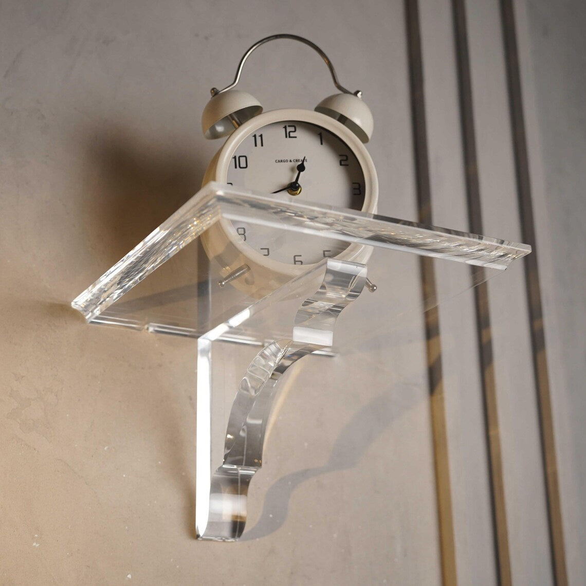 A clear acrylic floating shelf with a single mounting bracket
