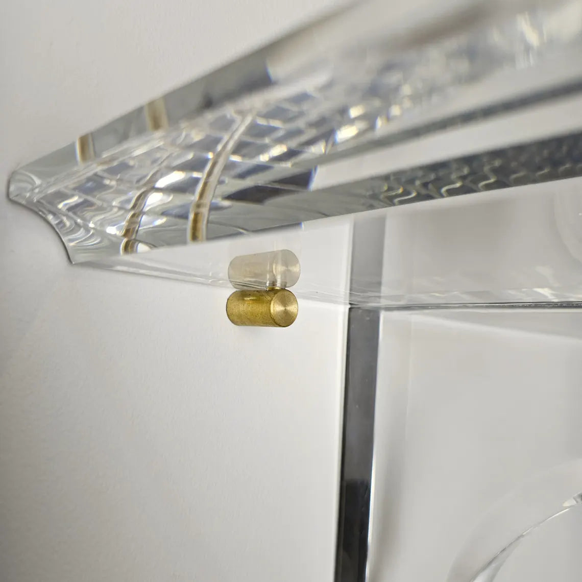 A clear acrylic floating shelf with two mounting brackets
