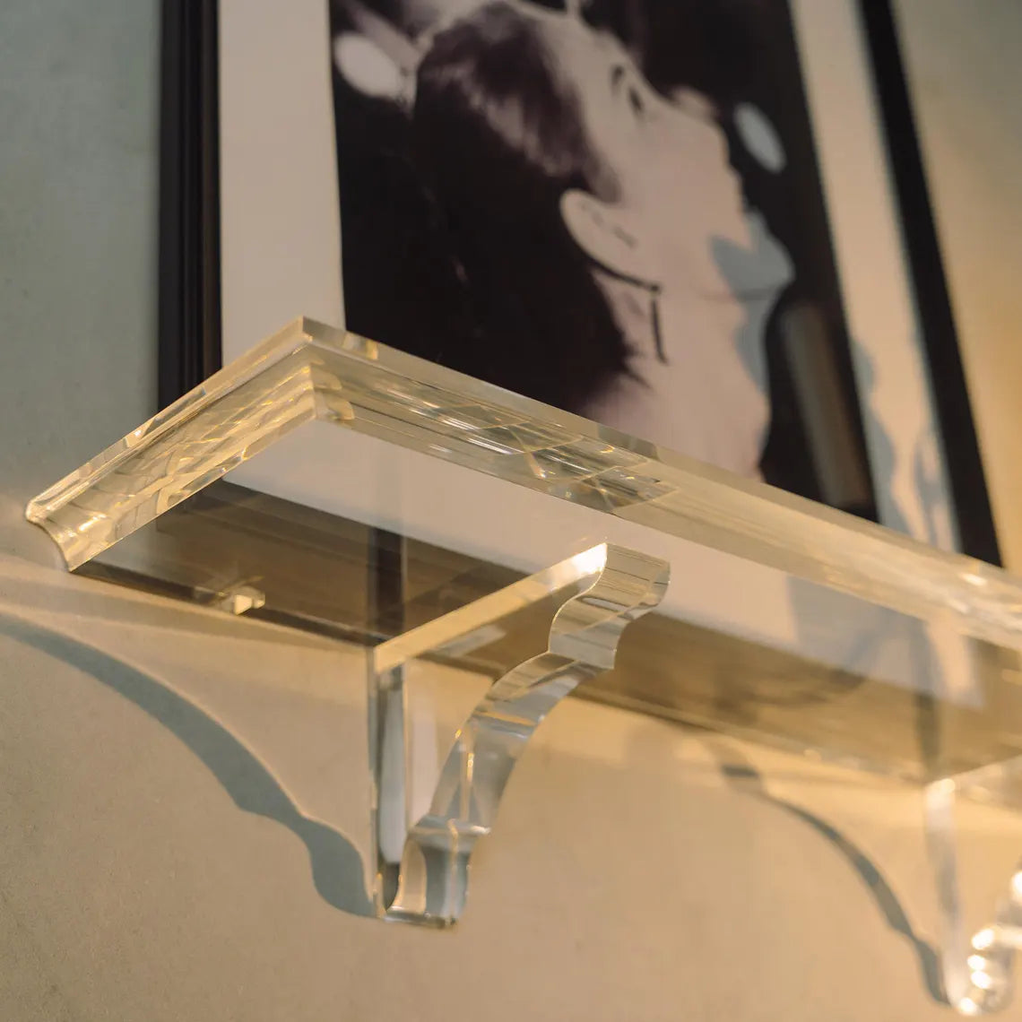 A clear acrylic floating shelf with two mounting brackets