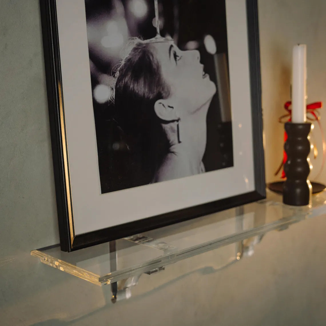 A clear acrylic floating shelf with two mounting brackets