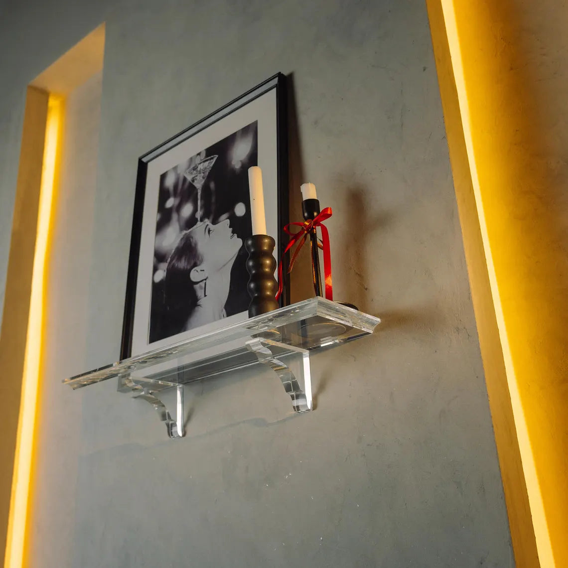 A clear acrylic floating shelf with two mounting brackets