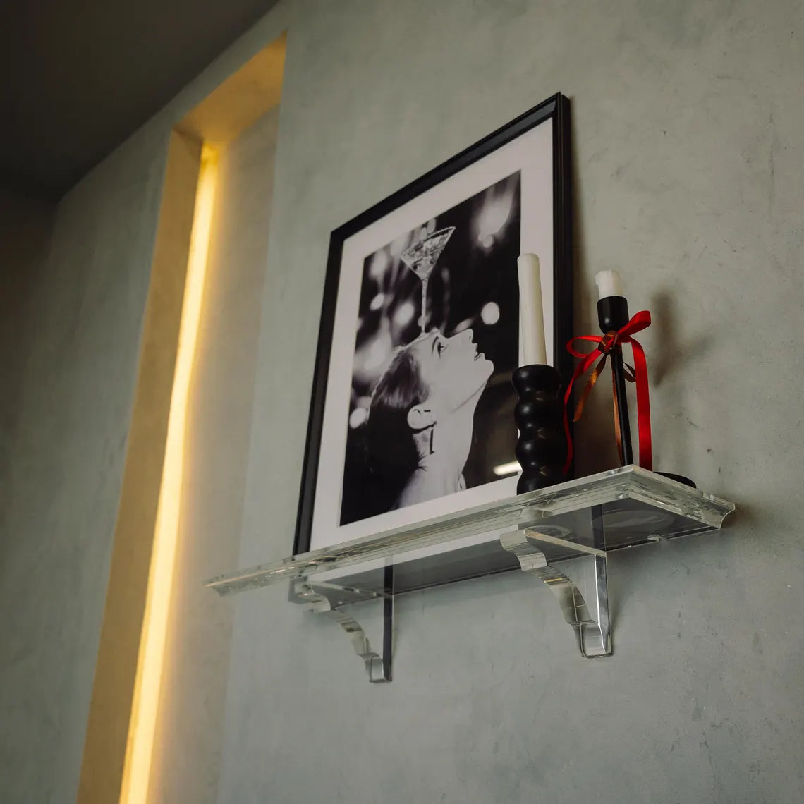A clear acrylic floating shelf with two mounting brackets