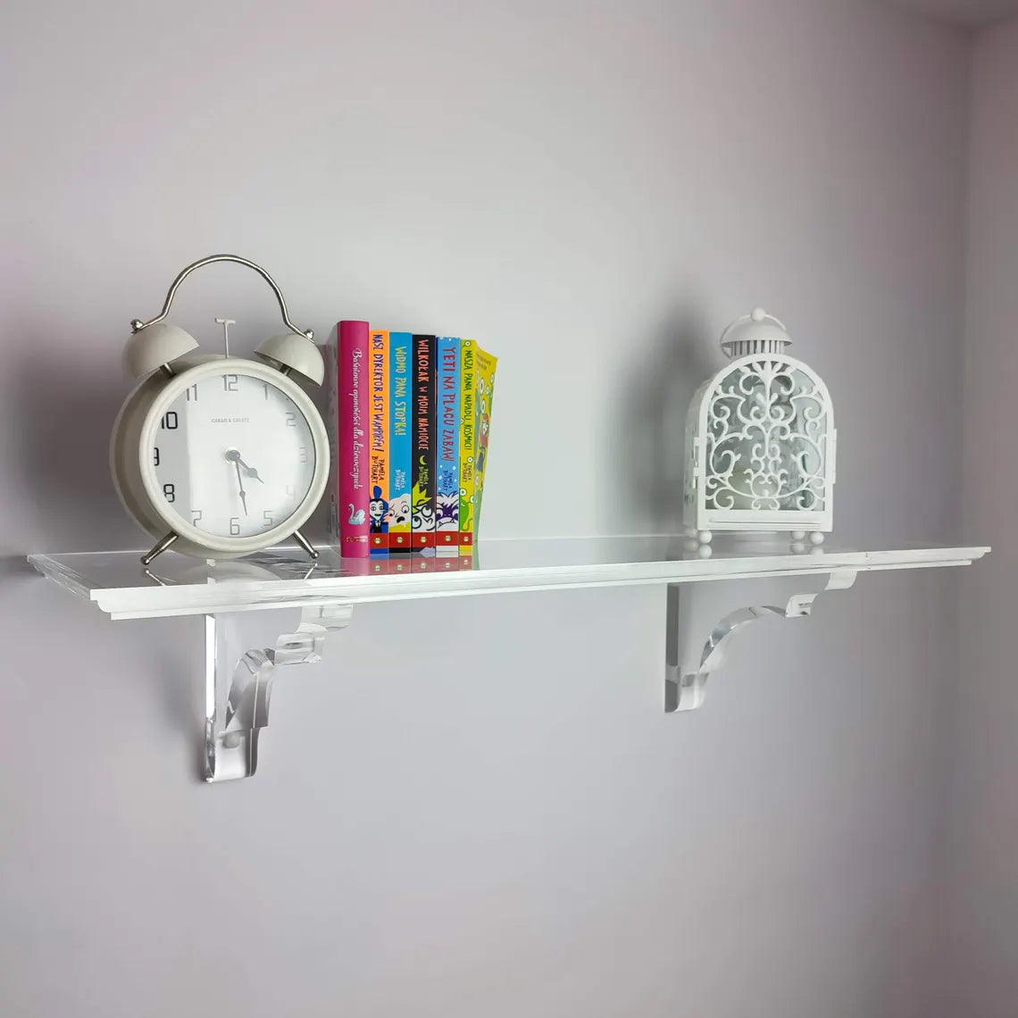 A clear acrylic floating shelf with two mounting brackets