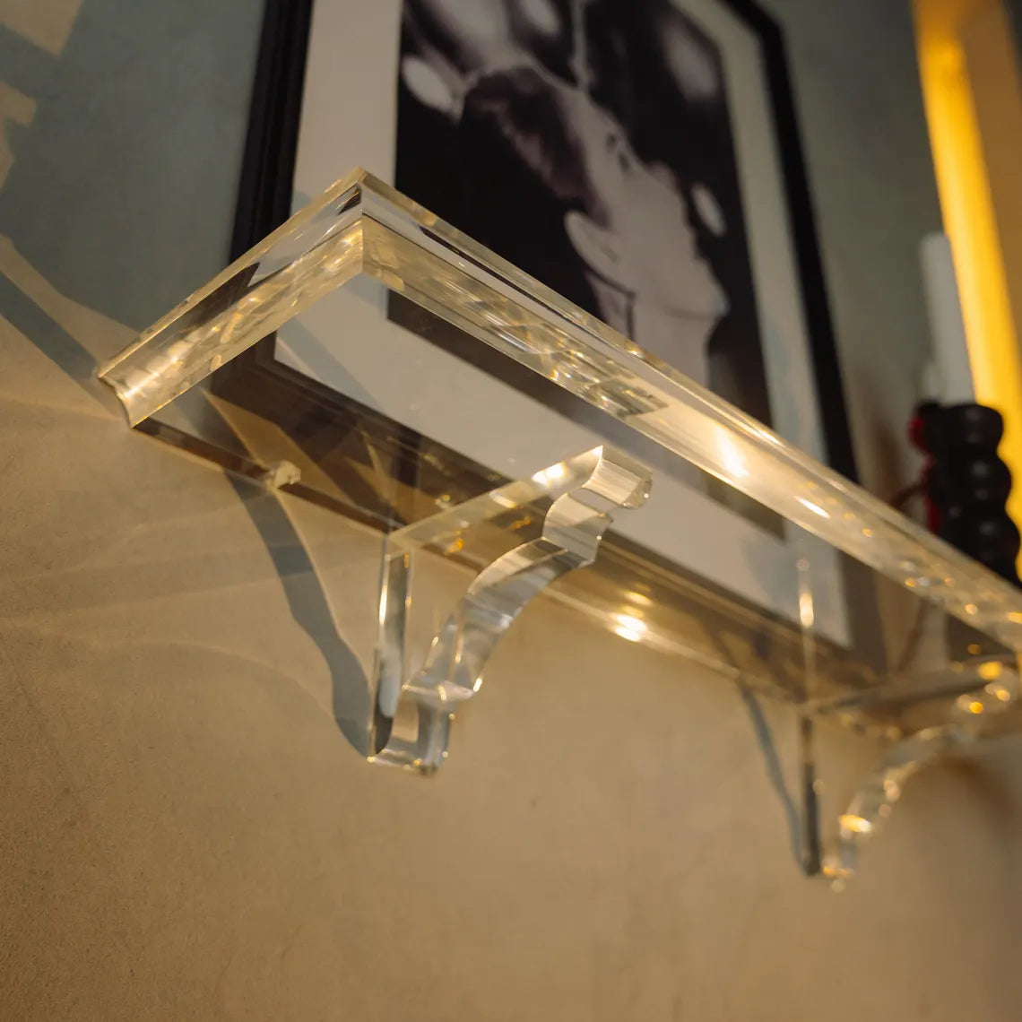 A clear acrylic floating shelf with two mounting brackets