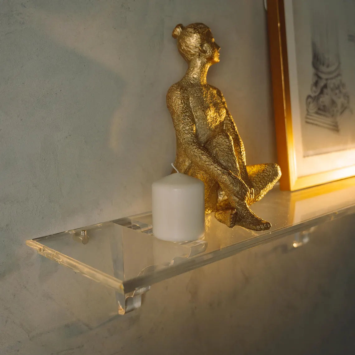 A clear acrylic floating shelf with three mounting brackets