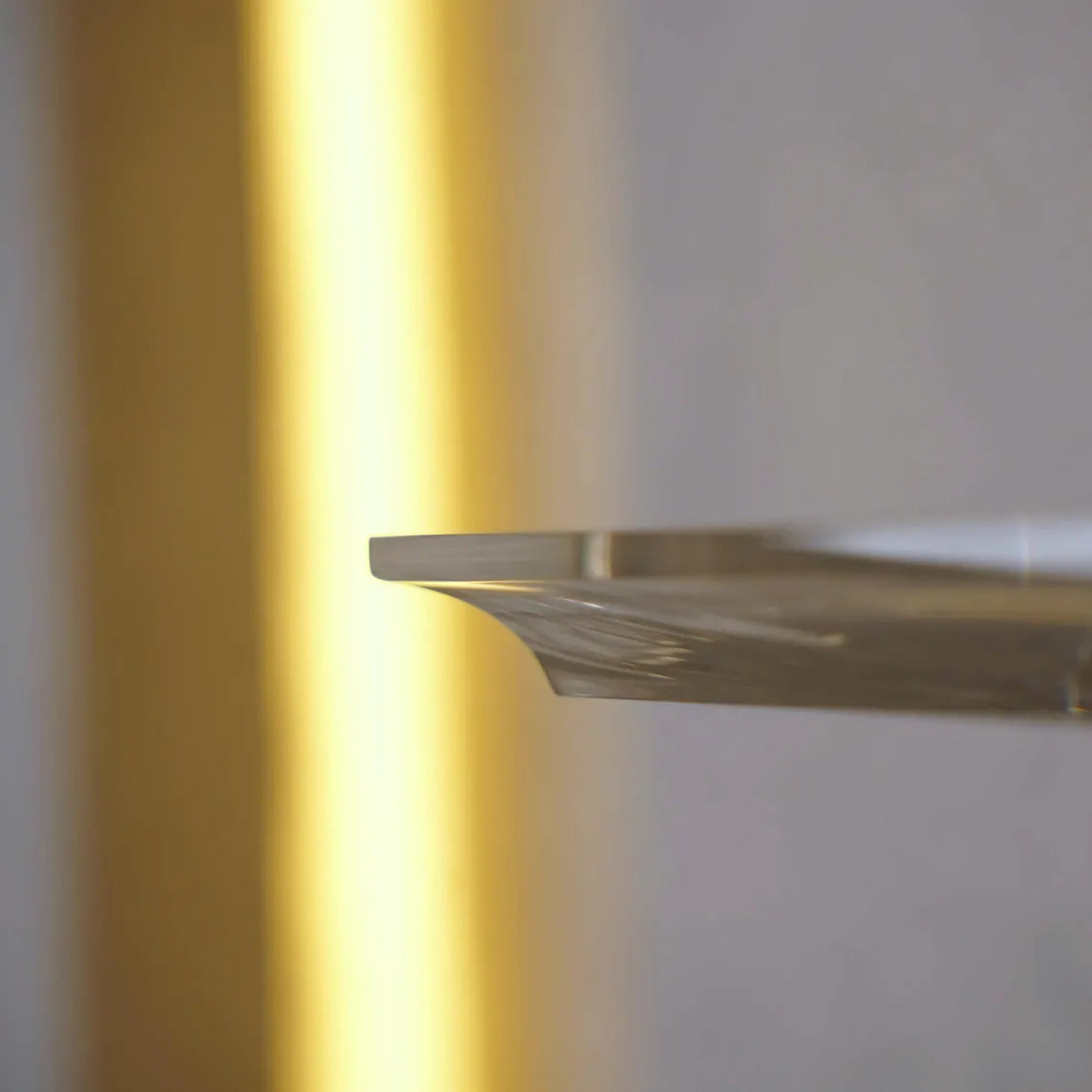A clear acrylic floating shelf with three mounting brackets