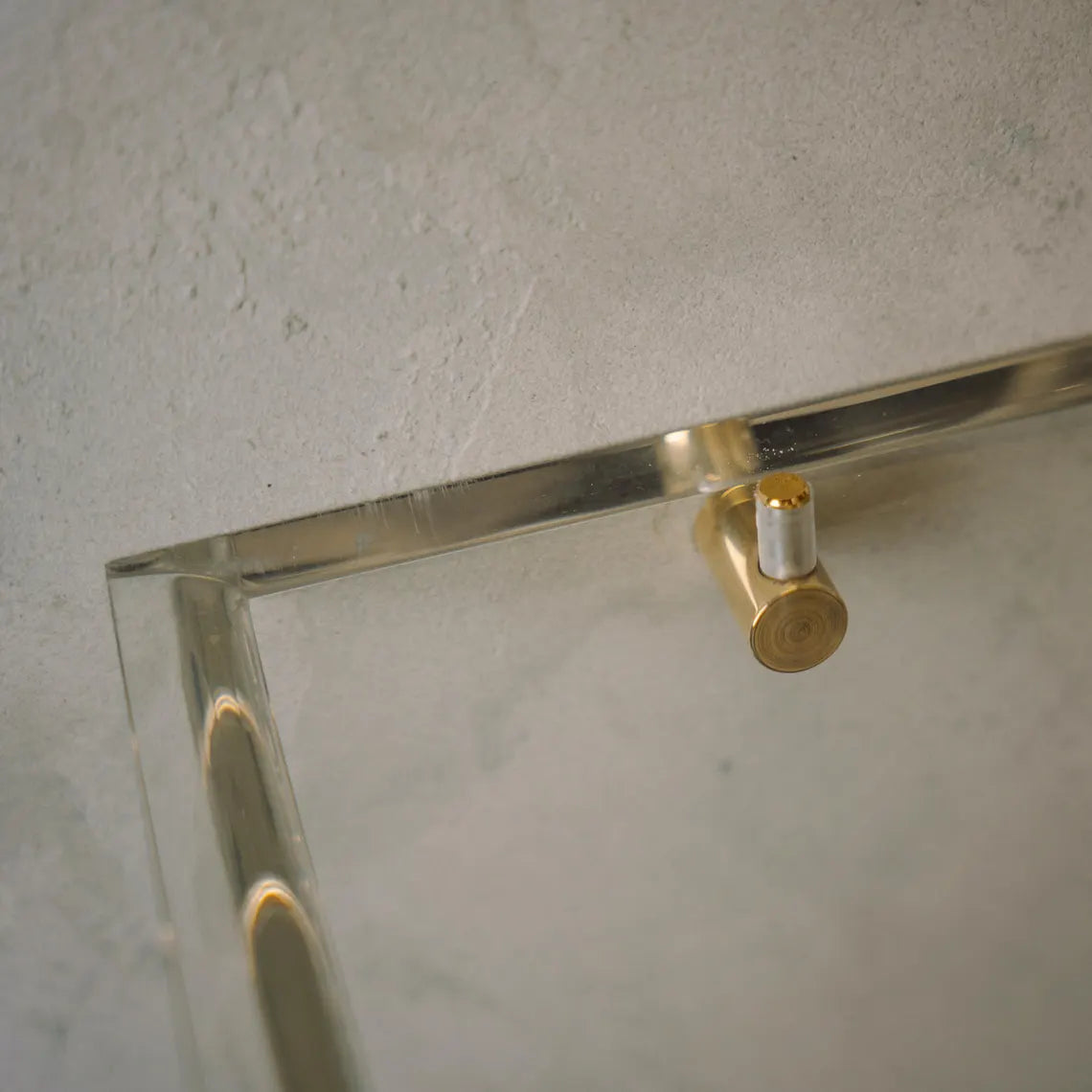 A clear acrylic floating shelf with three mounting brackets
