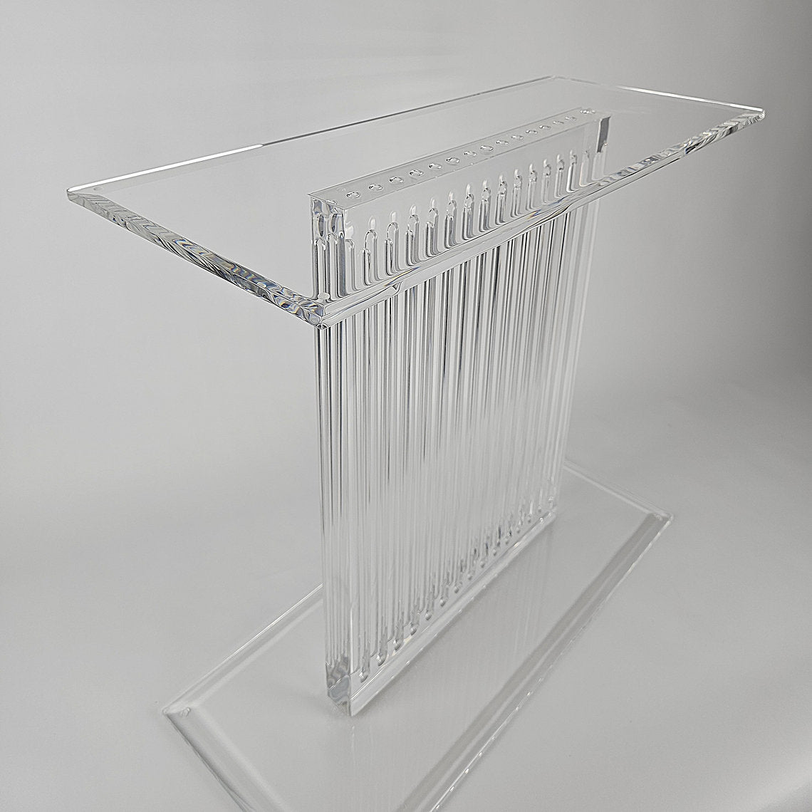 Sculptural acrylic table base with fluted design and reflective surface