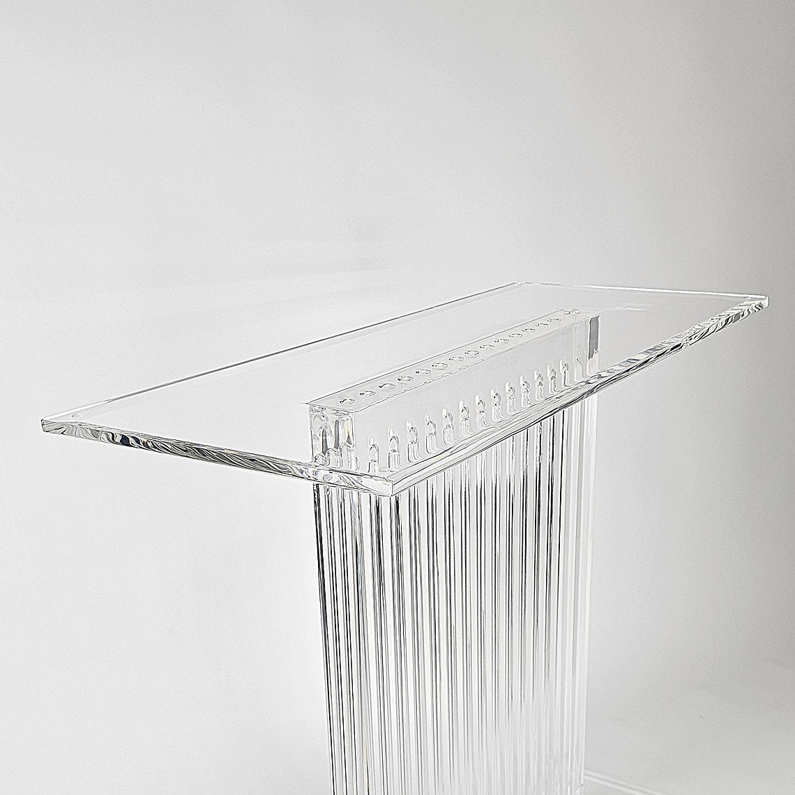 Sculptural acrylic table base with fluted design and reflective surface