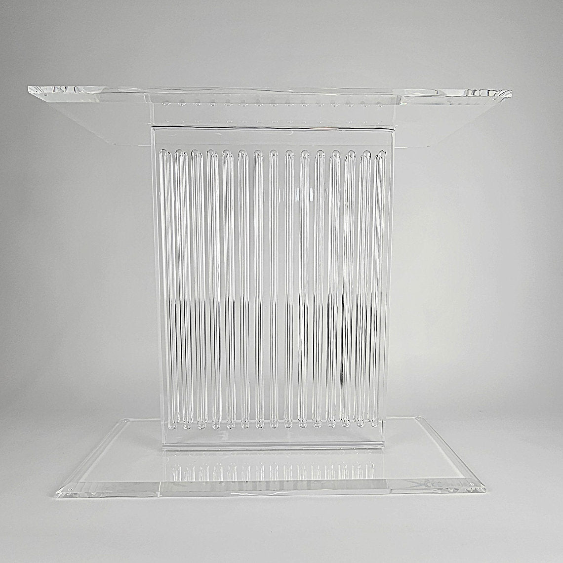 Sculptural acrylic table base with fluted design and reflective surface