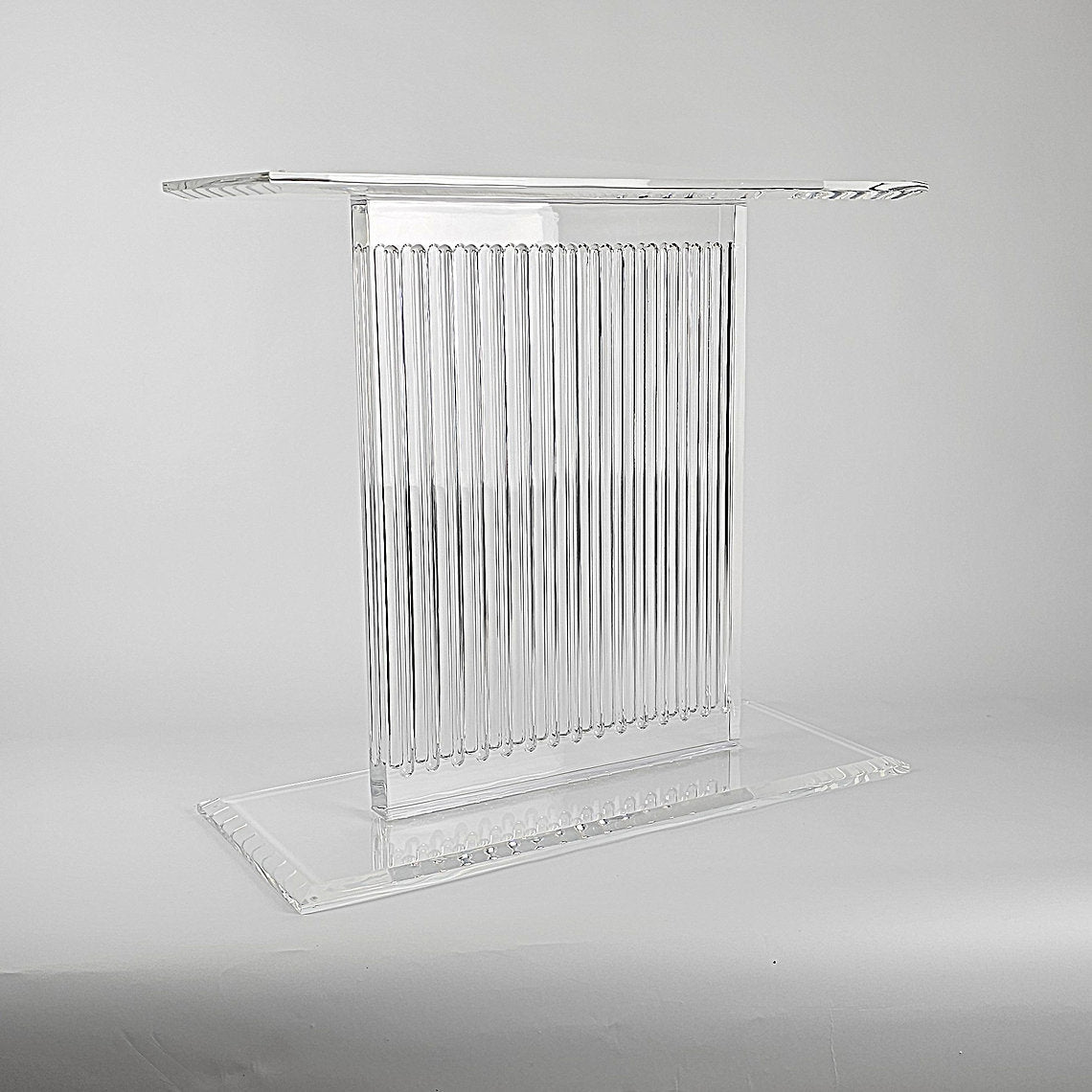 Sculptural acrylic table base with fluted design and reflective surface