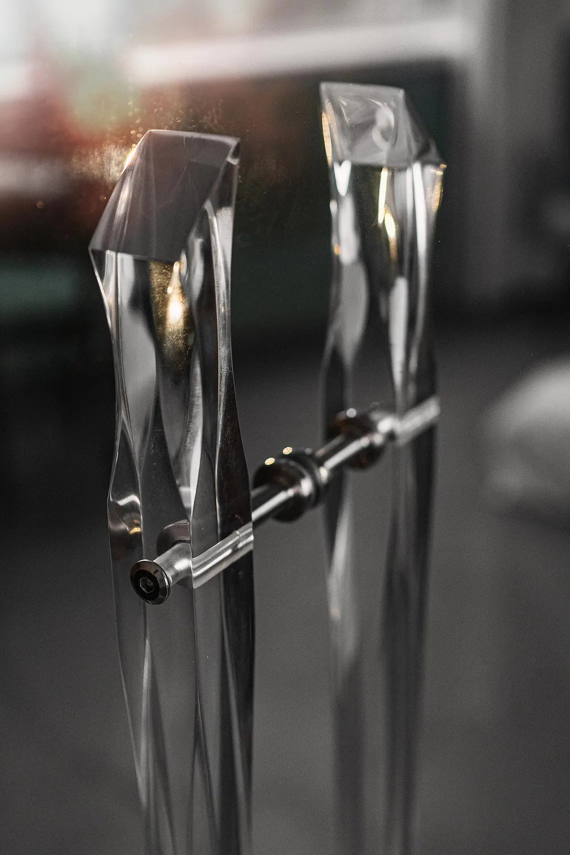 Clear acrylic door pull with flowing edges and chrome or gold accents