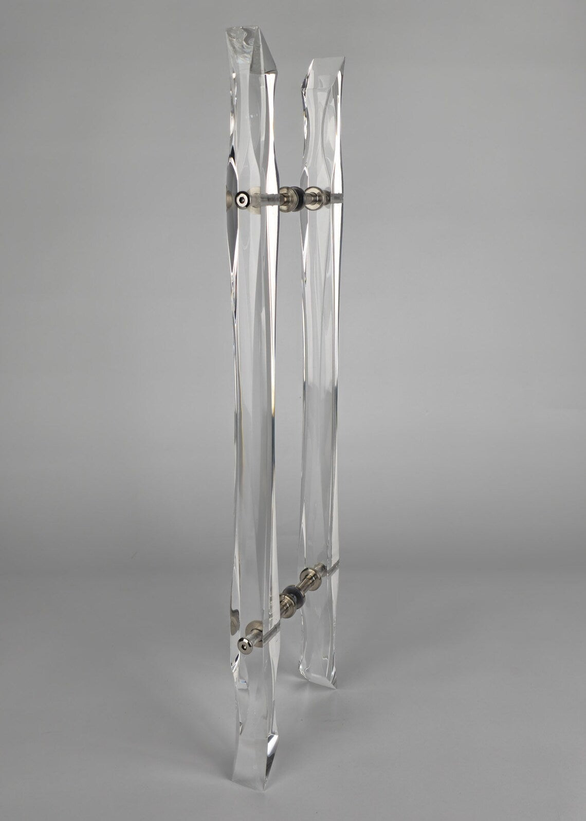 Clear acrylic door pull with flowing edges and chrome or gold accents