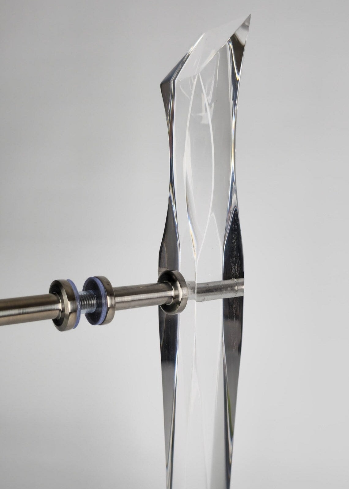 Clear acrylic door pull with flowing edges and chrome or gold accents