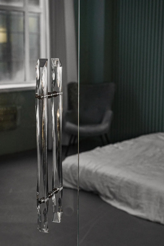 Clear acrylic door pull with flowing edges and chrome or gold accents
