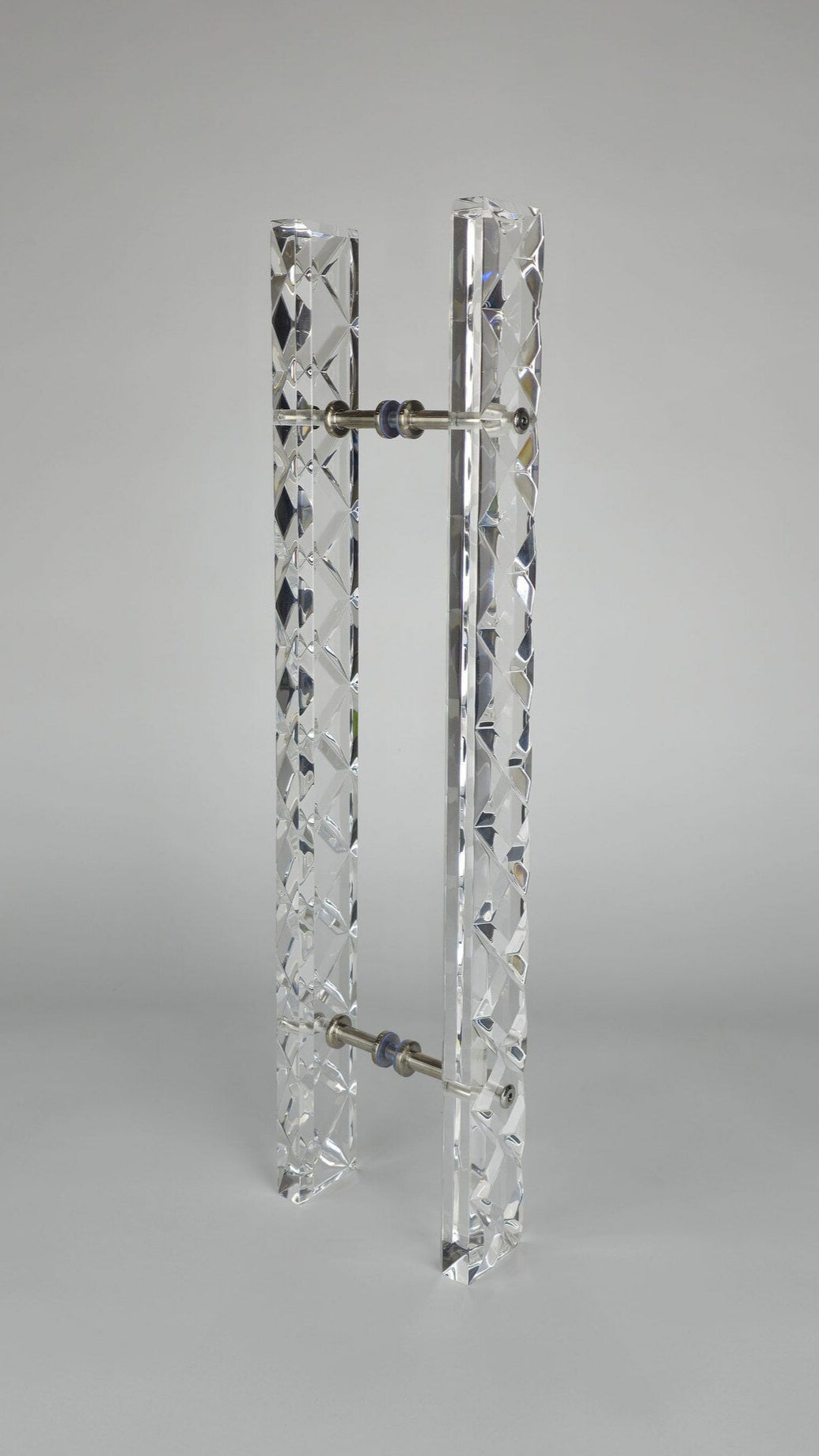 Clear acrylic door pull with a criss-cross pattern and chrome or gold accents