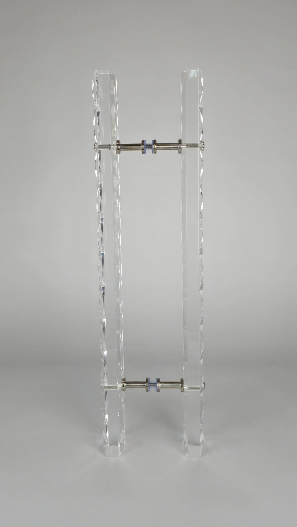 Clear acrylic door pull with a criss-cross pattern and chrome or gold accents