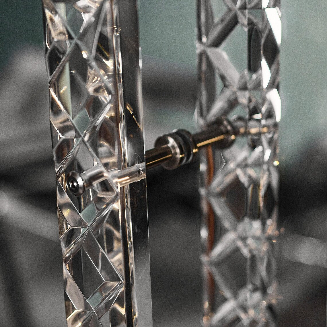 Clear acrylic door pull with a criss-cross pattern and chrome or gold accents