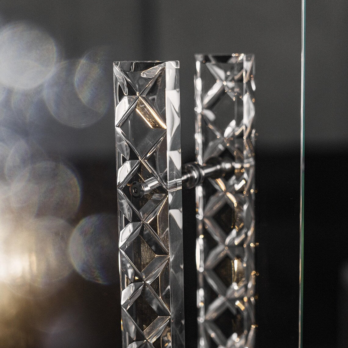 Clear acrylic door pull with a criss-cross pattern and chrome or gold accents