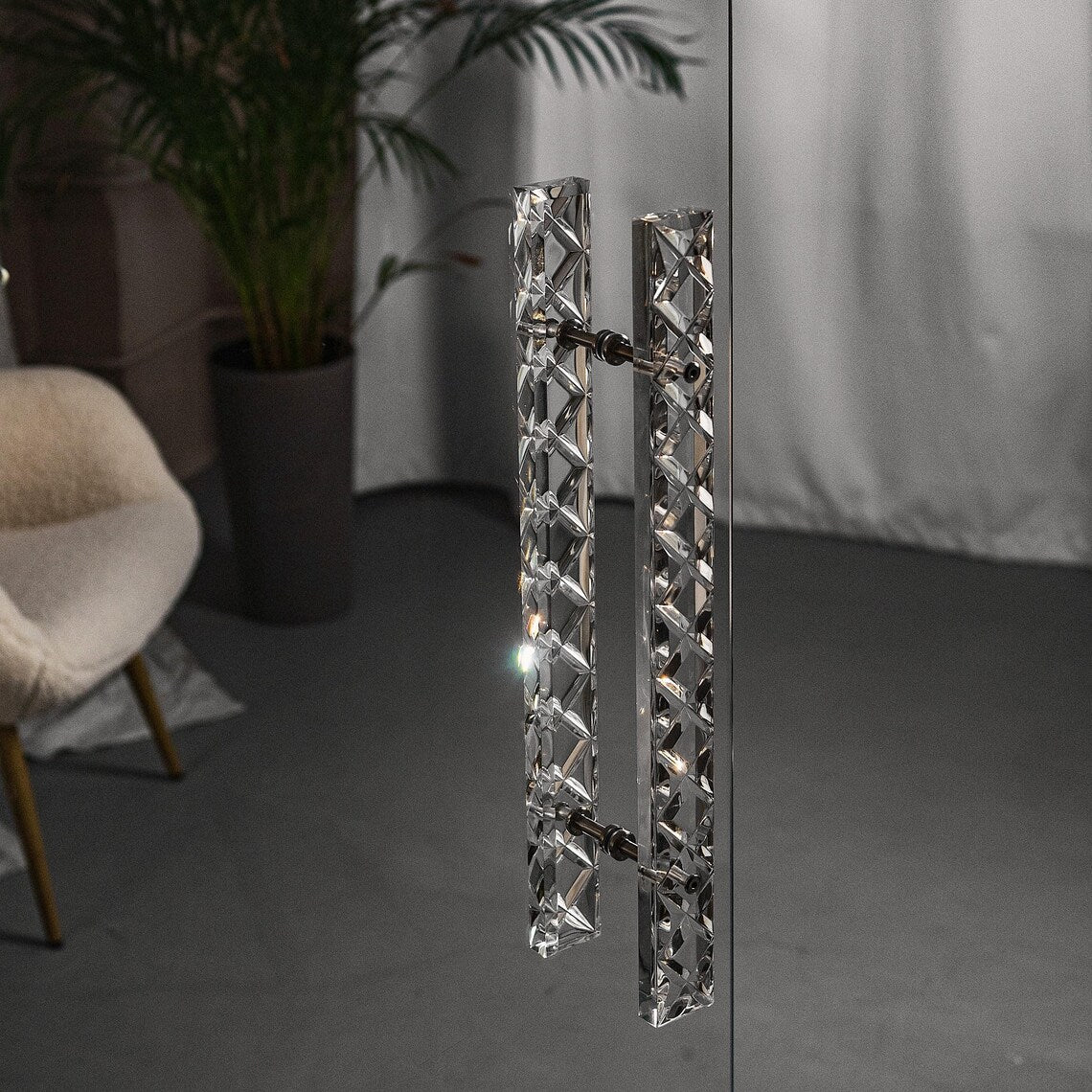 Clear acrylic door pull with a criss-cross pattern and chrome or gold accents