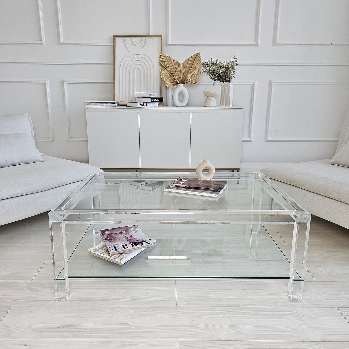 Clear acrylic coffee table with a minimalist style and lower shelf