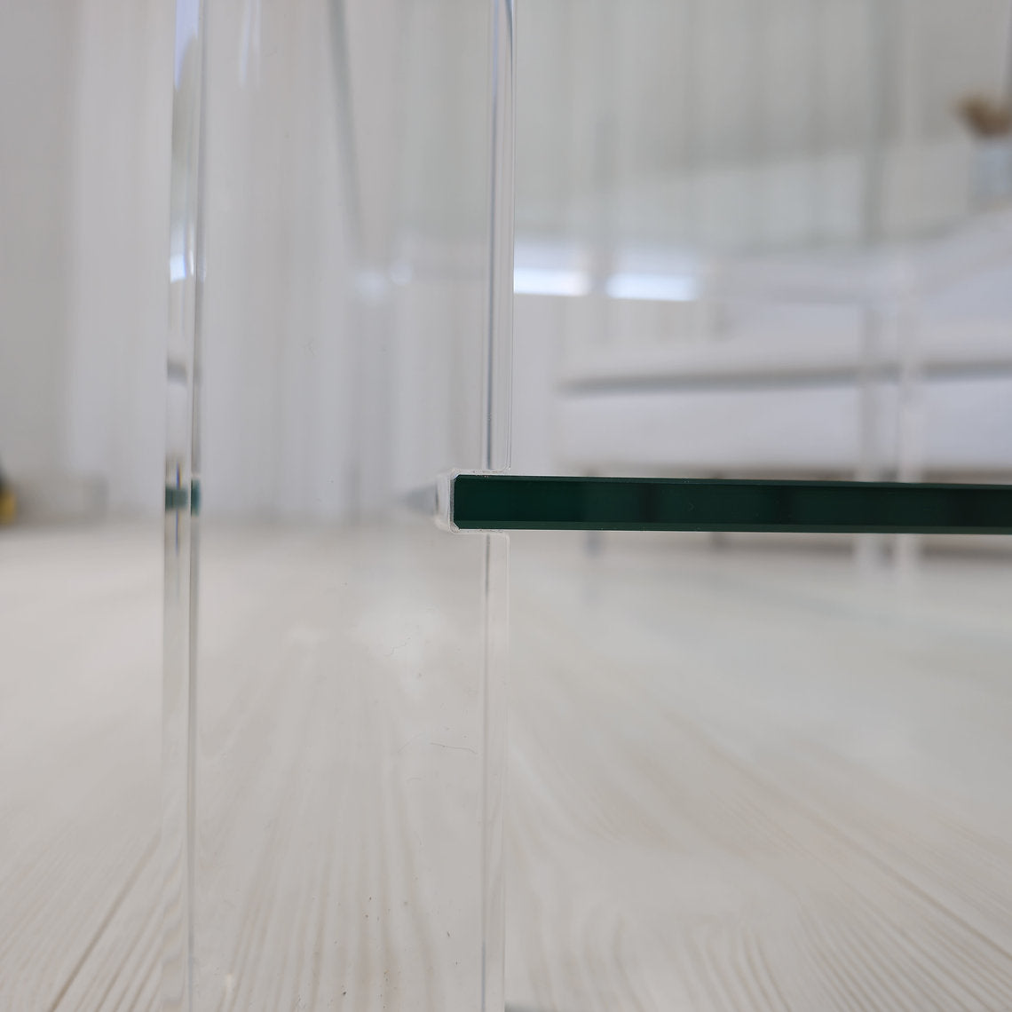 Clear acrylic coffee table with a minimalist style and lower shelf