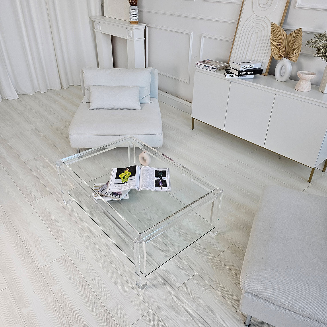 Clear acrylic coffee table with a minimalist style and lower shelf