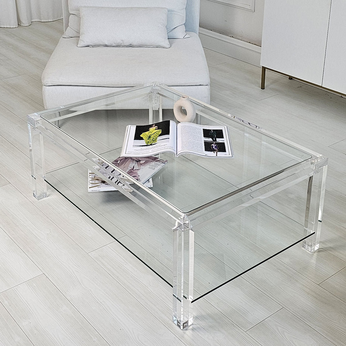Clear acrylic coffee table with a minimalist style and lower shelf
