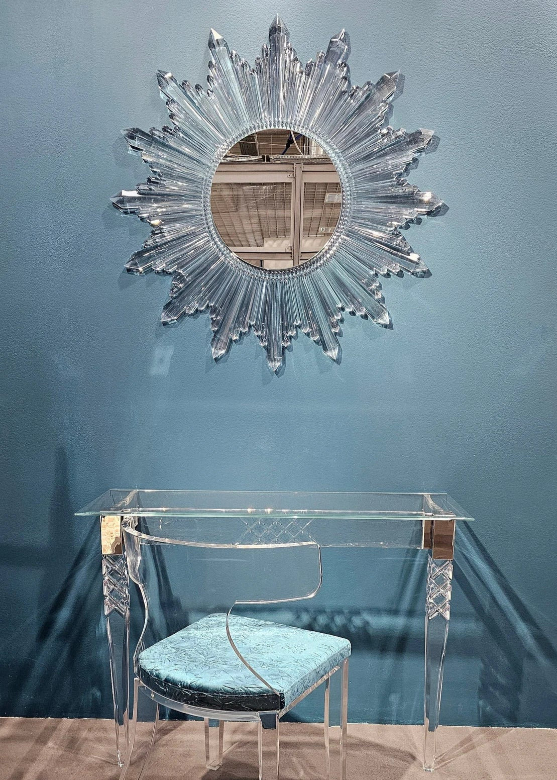 Circular sunburst wall mirror with clear acrylic crystals radiating from the center