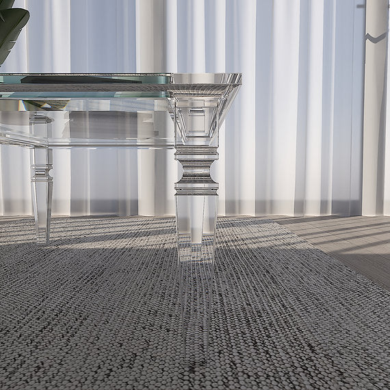 Clear acrylic coffee table on a textured gray floor.