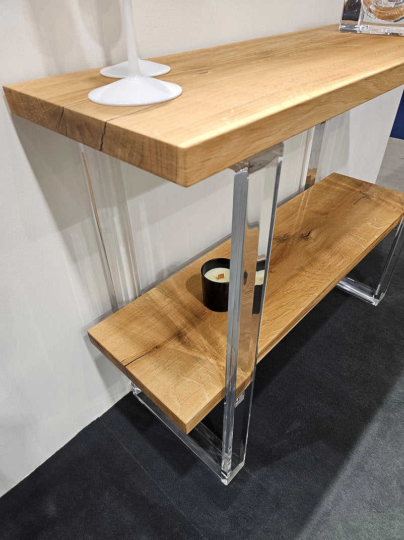 Clear acrylic console table with a light wood top and shelf