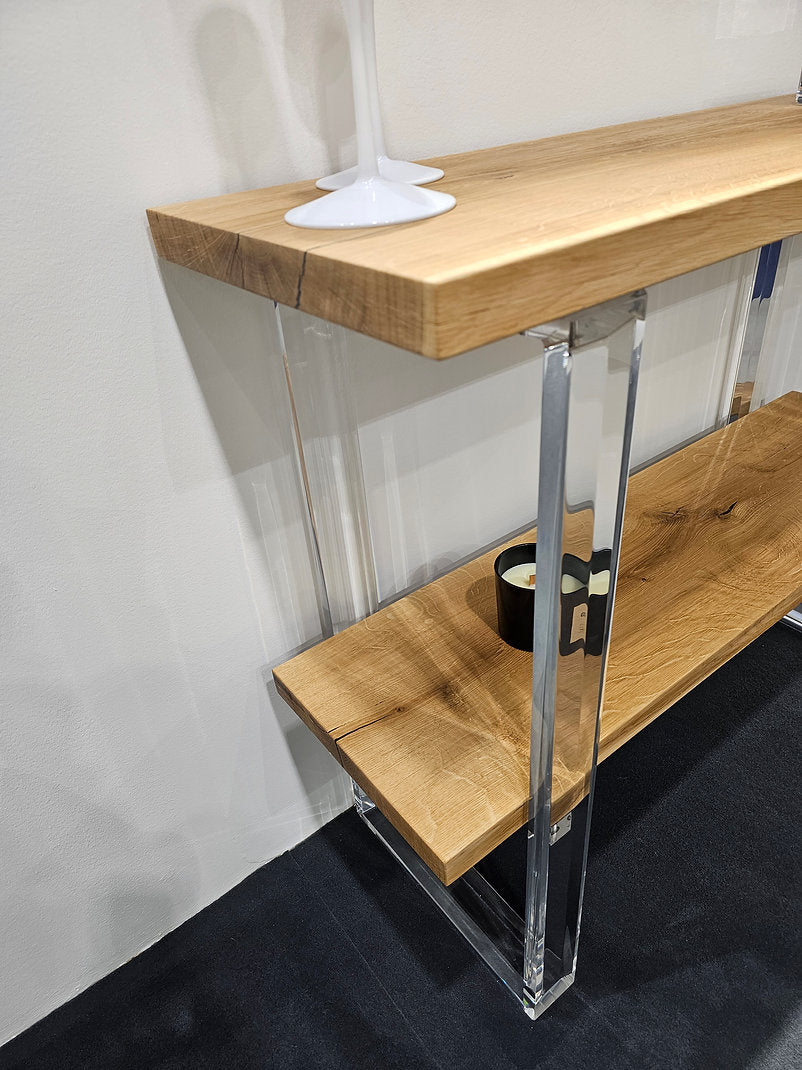 Clear acrylic console table with a light wood top and shelf