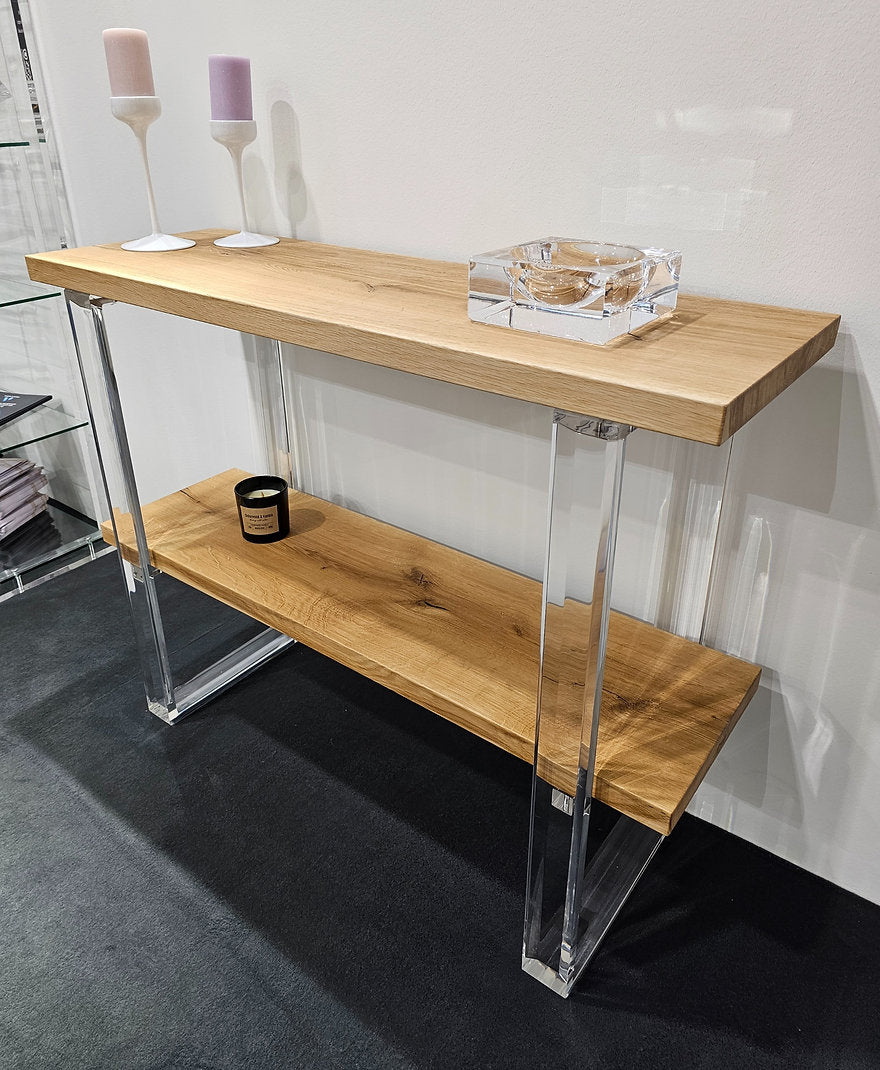 Clear acrylic console table with a light wood top and shelf