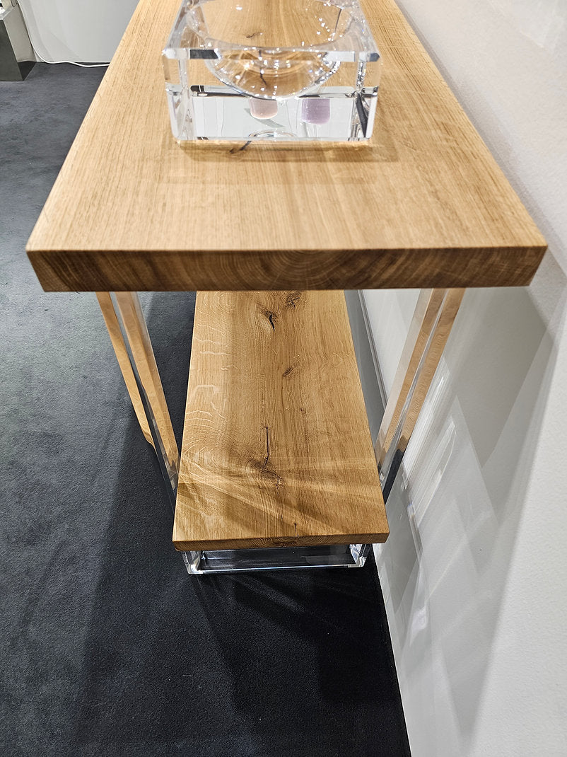 Clear acrylic console table with a light wood top and shelf