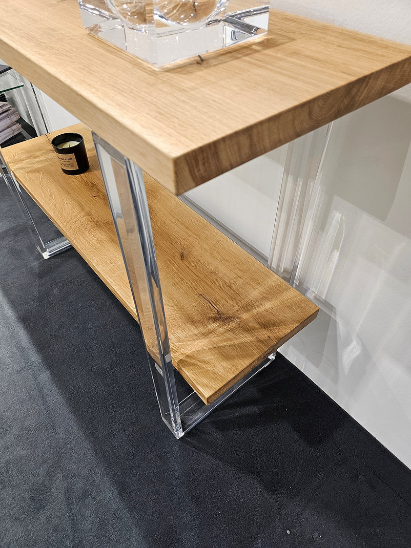 Clear acrylic console table with a light wood top and shelf