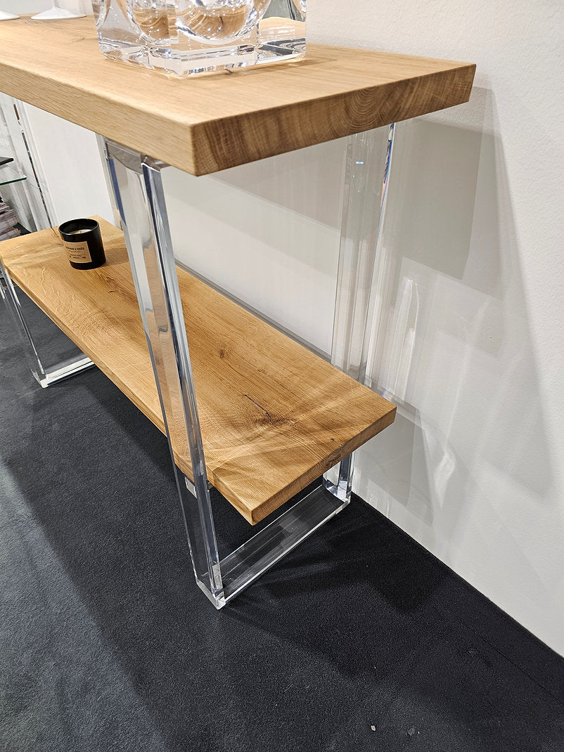 Clear acrylic console table with a light wood top and shelf