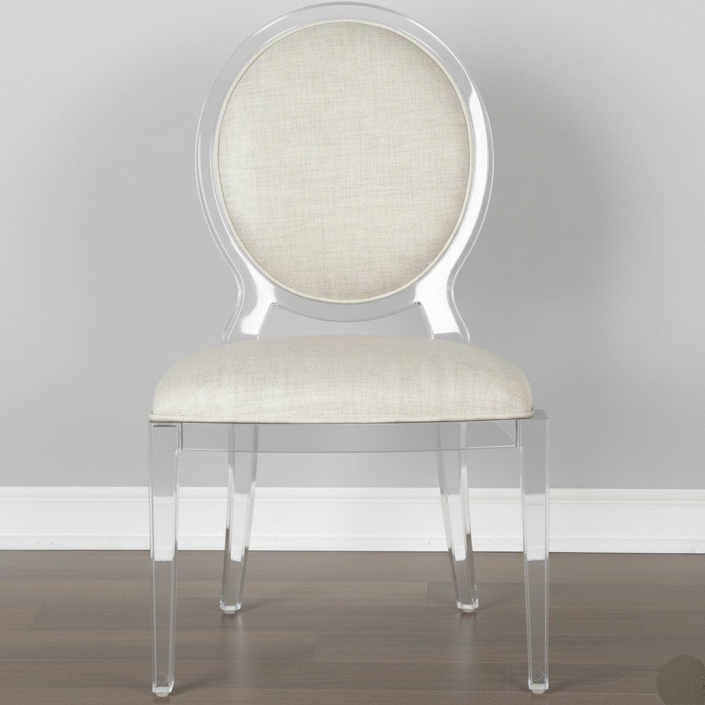 Clear acrylic chair with beige upholstered seat and backrest on a gray background