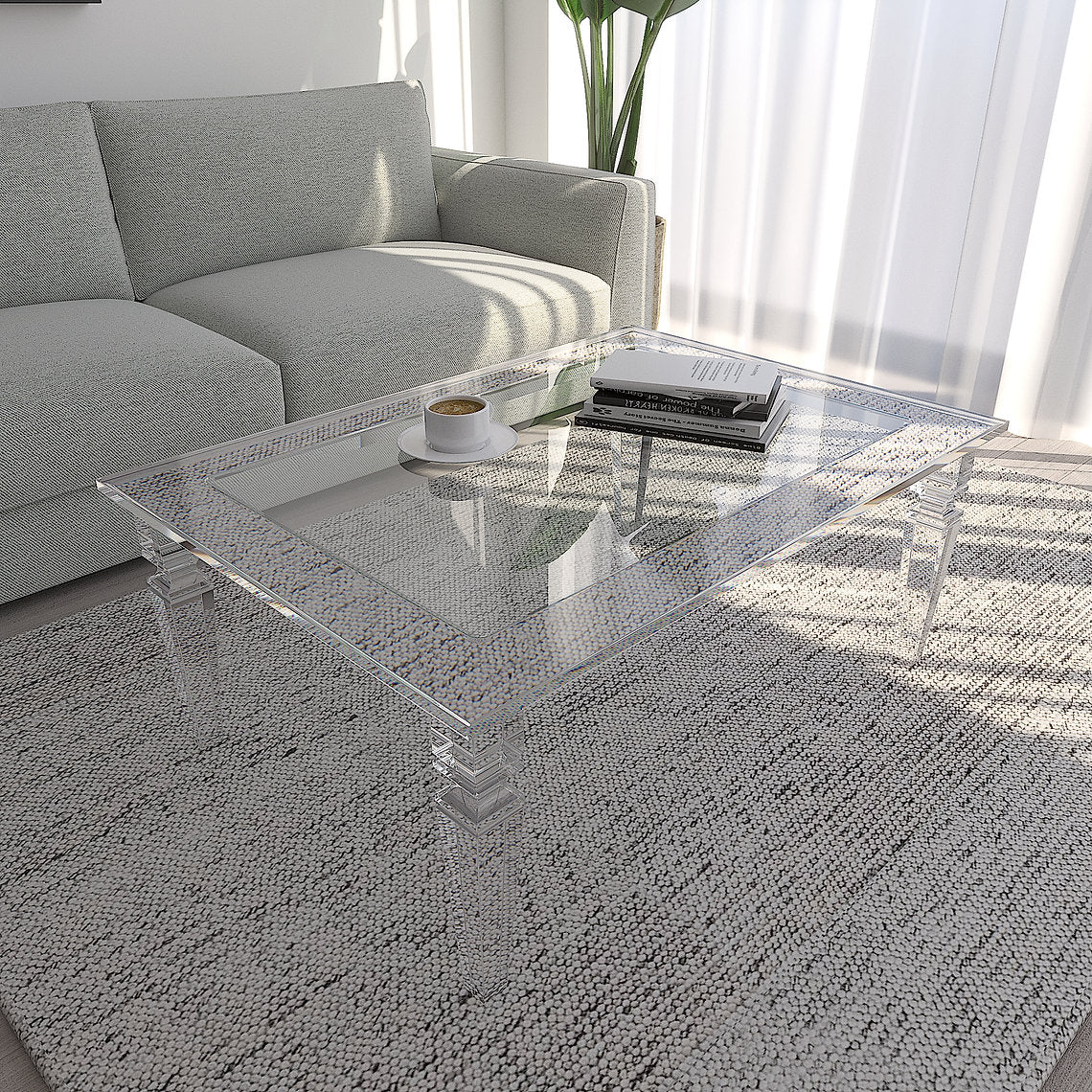 Clear acrylic coffee table in a living room with a gray sofa and rug.