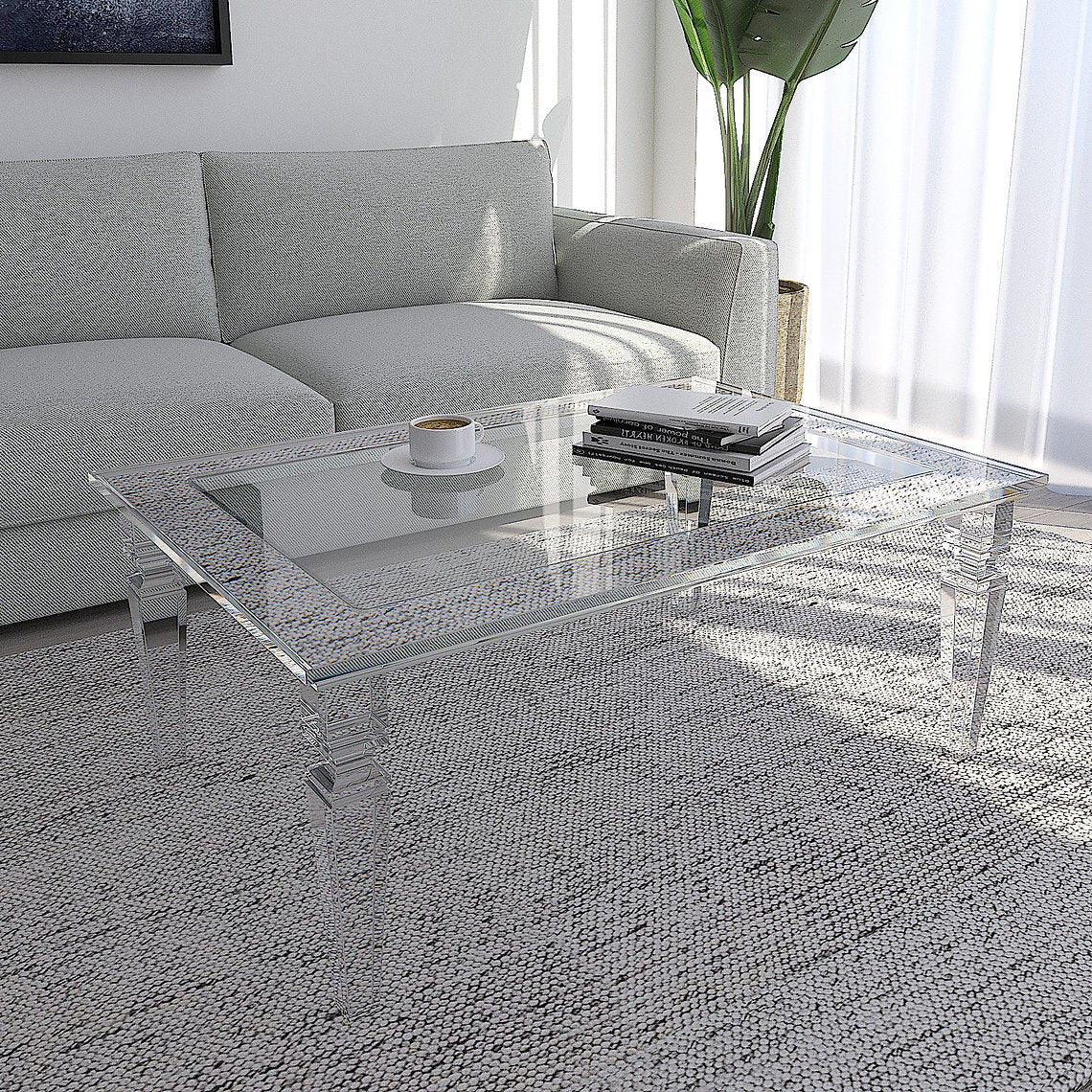 Modern living room with a clear acrylic coffee table, gray sofa, and decorative items.